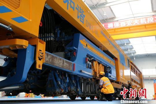 圖為工人正在清理大型養(yǎng)路機(jī)械。　張遠(yuǎn) 攝